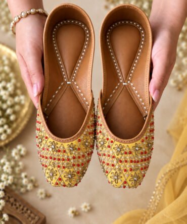 Mehak yellow juttis with gold and red embroidered detailing by Azayaa