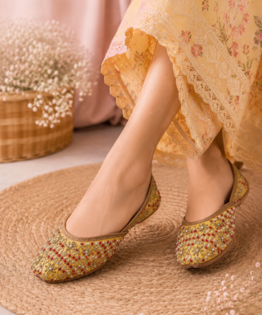 Mehak yellow juttis with gold and red embroidered detailing by Azayaa