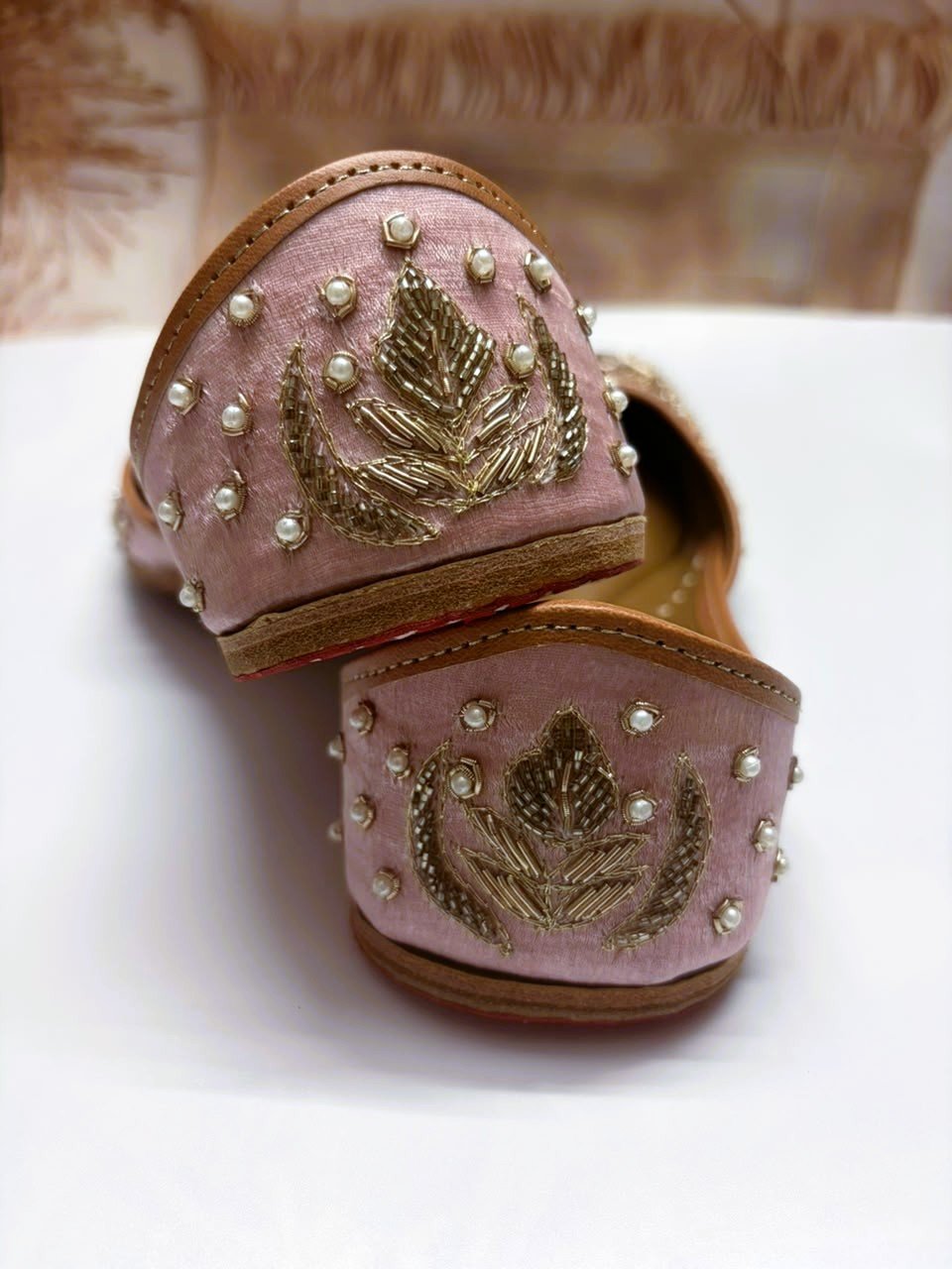 Close-up of pink Rose Mist juttis with intricate pearl embellishments