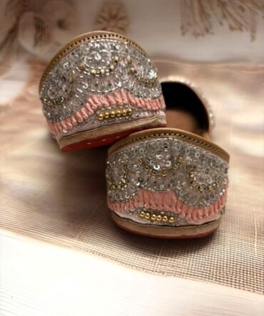 Close-up of Stardust juttis featuring silver embellishments on pink fabric