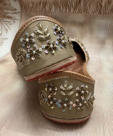 Close-up of Zohra Punjabi juttis with blue sequin and gold embroidery